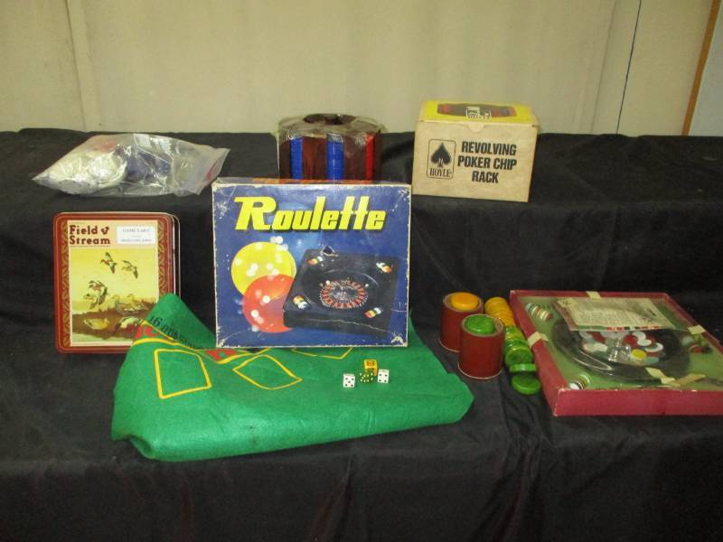 lot 76 image: Roulette, poker chips, 2 revolving pocker chip rack, dice, shaker cups, game laws