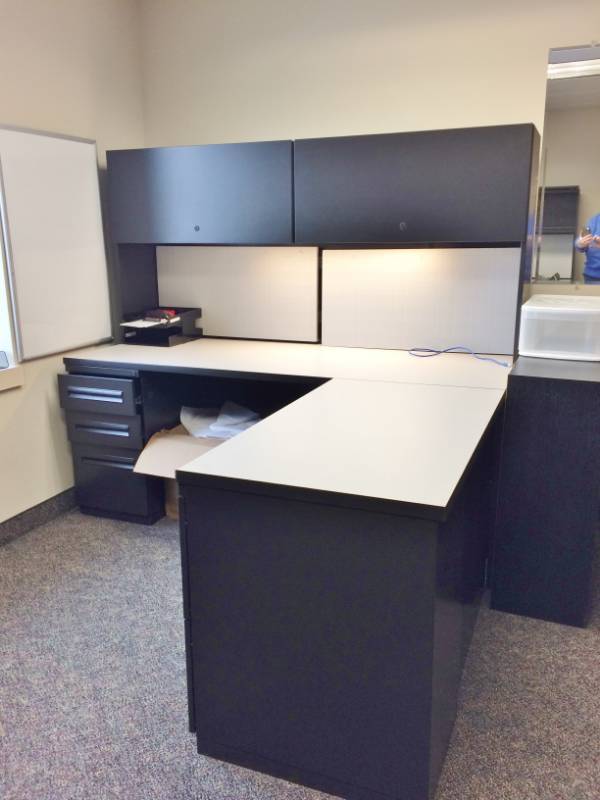 lot 1 image: MSRP $3000 High Quality Hayworth Executive Office Workstation Desk With Right Return, 1-3 Drawer Filing Cabinet, 1-2 Drawer Filing Cabinet, Lighted Overhead Slide Up 2 Door Cabinets Sleek Chic BlackWhite Design Excellent Premium Condition 