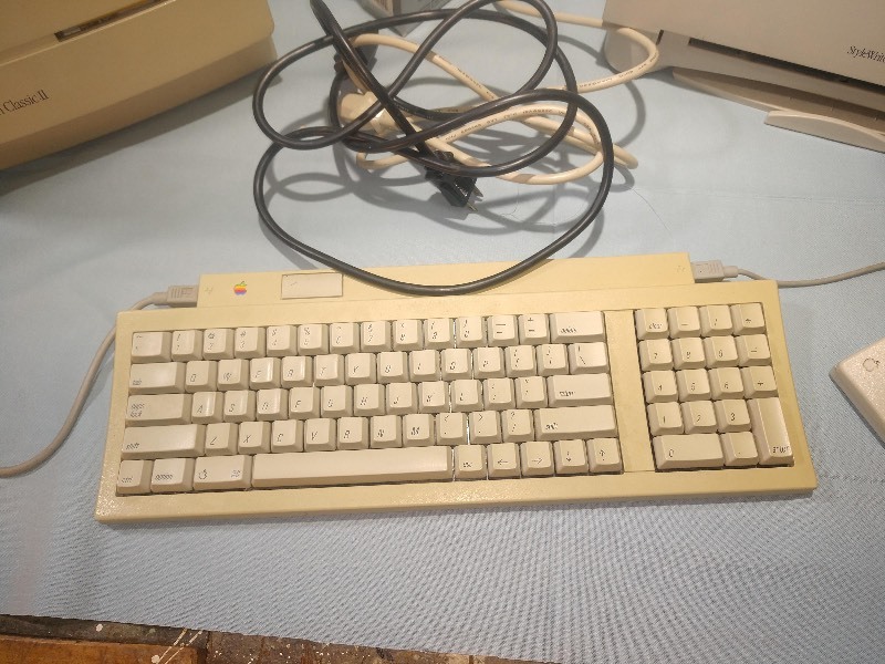 lot 24 image: POWERS ON Vintage Macintosh Classic II w Keyboard, Vintage Apple StyleWriter II, Vintage Imation 3M Discs and Cords.