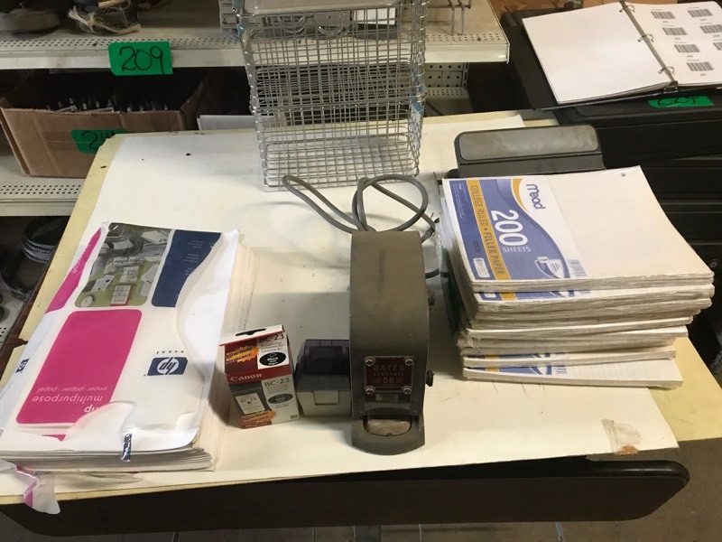 lot 248 image: Shelf of Electric Stapler Bates Model 56, Three Baskets, 1 Metal, 2 Plastic (new), Ten packets of lined notebook paper 200ctpacket, One Paper Punch and pkg of Printer Paper