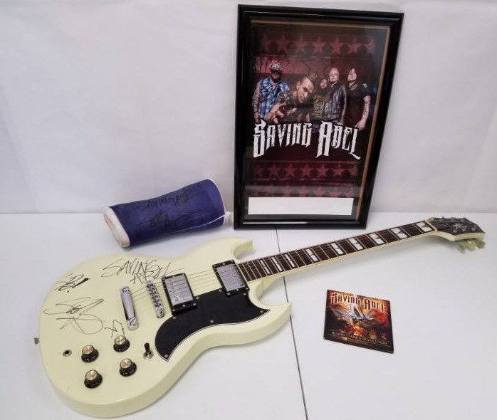 lot 1 image: Autographed Jay Turser guitar & band picture with a cast and Blood Stained Revolution CD from Saving Able low reserve