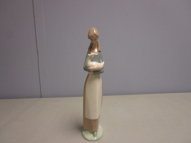 lot 699 image: LLADRO NAO FIGURINE OF GIRL HOLDING DUCK IN HER ARMS