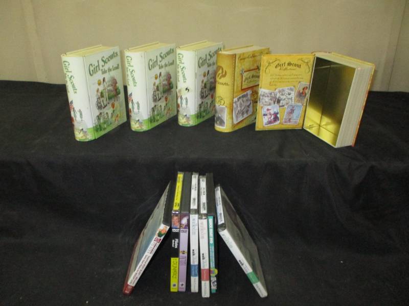 lot 81 image: Girl Scout Cookie Tin Boxes that look like books and workout dvds