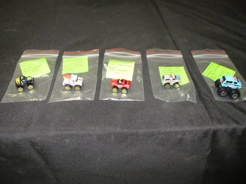 lot 142 image: Micro Machine Monster Truck Ford Bronco Gris Road Champs 1987, , Kenworth Noir Road Champs 1987, Depanneuse White, Blanc Road Champs 1987, annd Ford Thunderbird and Monster Truck Van Ford Astro Star Blue Road Champs Big Wheels 1987,  Rouge Rad Champs 1987