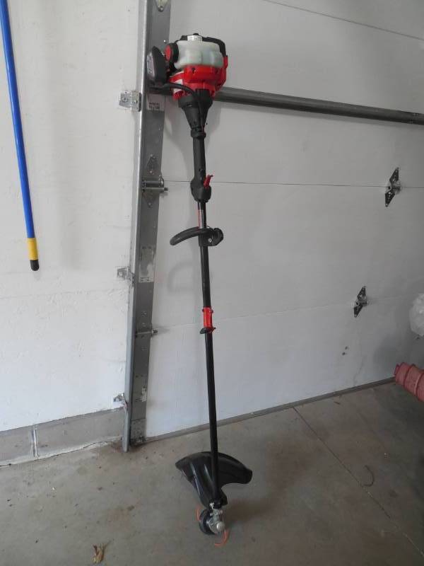 lot 64 image: Troy-Bilt 25 cc 2-Cycle Straight Shaft Attachment Capable Gas Trimmer with JumpStart Capabilities