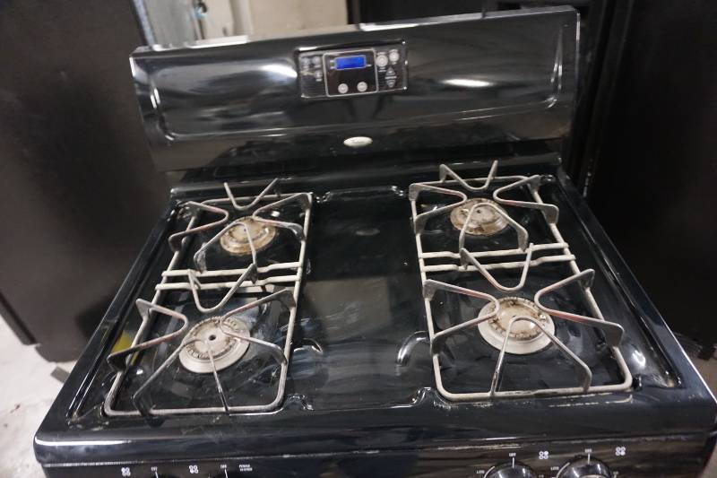 lot 25 image: Whirlpool Gas RangeStove With Under Counter Mount Fan