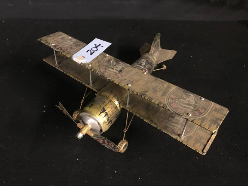 lot 204 image: Pigs Eye beer can airplane sculpture