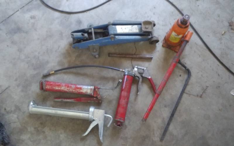 lot 50 image: Bottle Jack, Floor Jack, 2-Grease Guns, Tire Iron, Lg Caulk Gun