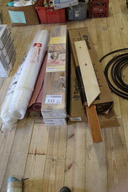 lot 335 image: Tarkett wood flooring. Two different styles, Five boxes and two. Comes with vaper barrier.