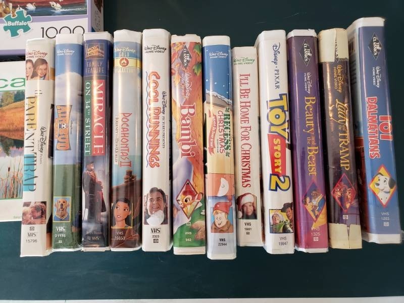 lot 41 image: (12) Disney Vhs Movies  (8) Puzzles  Cup Coasters