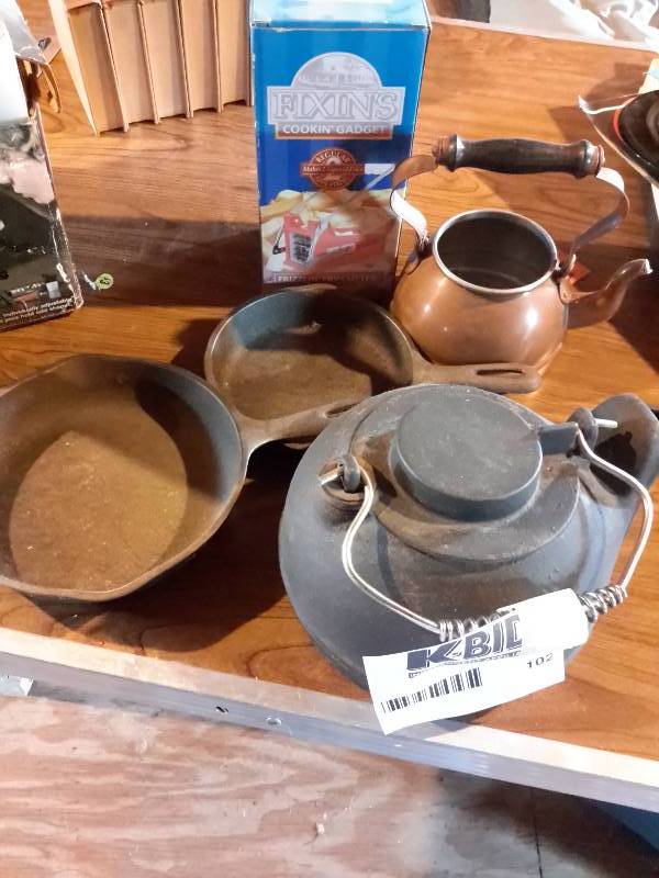 lot 102 image: 2 iron frying pans 1, heavy iron tea pot 1 copper tea pot(no cover)