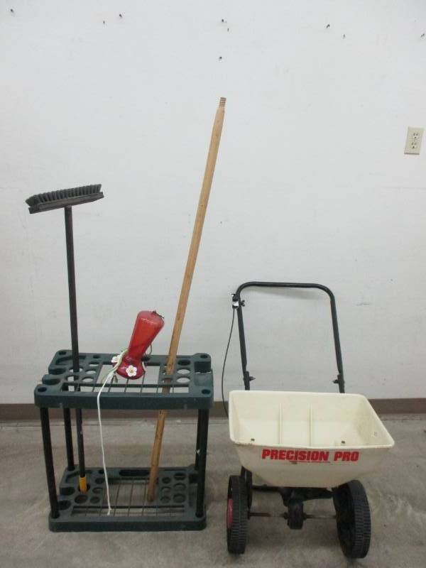 lot 27 image: Broom and tool cady, yard grass seeder and hummingbird feeder