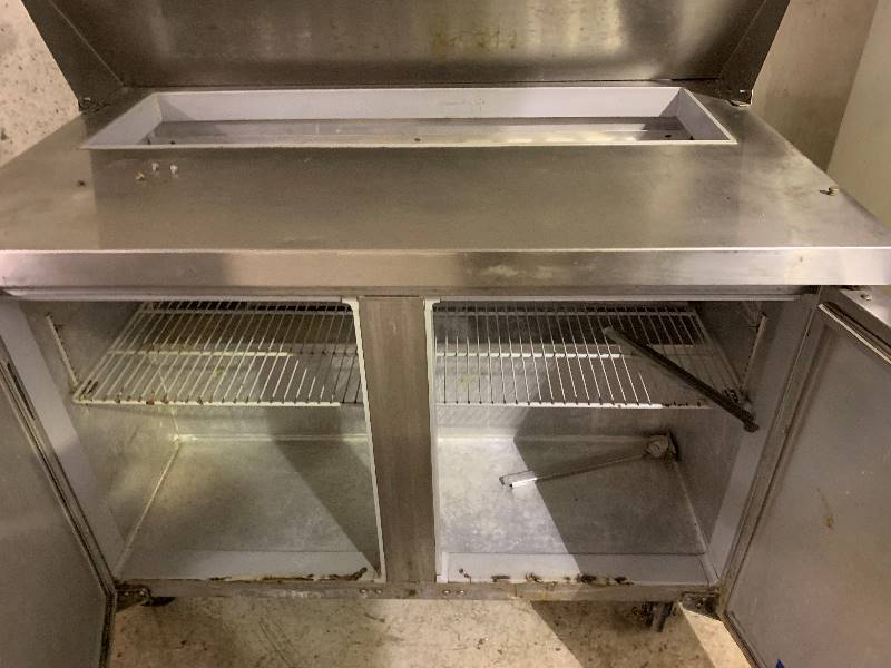 lot 22 image: Continental two door refrigerated prep table, NSF, caster mounted, 115 volts, 7.2 amps, 48x31.5x35H, 45 overall heightRuns Does not Cool