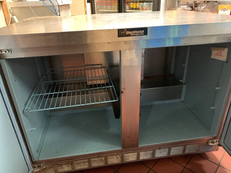 lot 22 image: Delfield, two door under counter refrigerated table, NSF, caster mounted, 115 volts, 7.2 amps, 48x31.5x35H, 45 overall heightRuns Cools