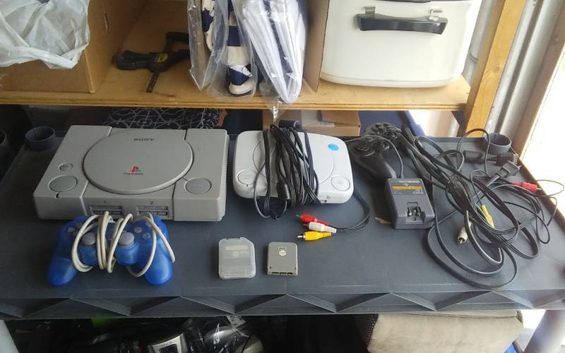 lot 25 image: 2-Sony Playstation 1s, 2-Remotes, 2-Memory Cards