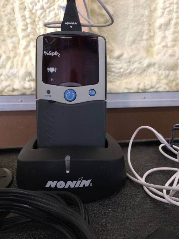 lot 81 image: MSRP $1200 Nonin PalmSAT 2500 Digital Hand-Held Pulse Oximeter With Charging Base - Looks To Have Been Used Just A Couple Times  Original Box Included