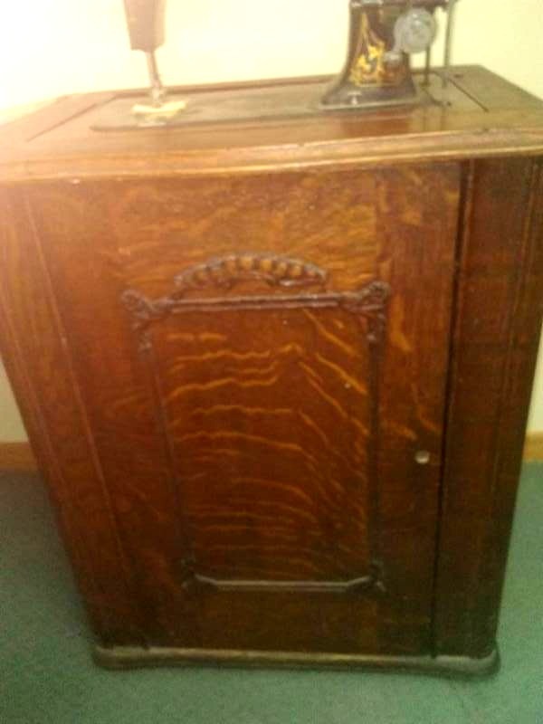 lot 33 image: Antique treadle machine and cabinet.