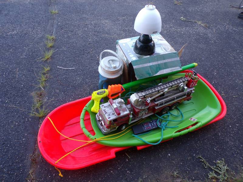 lot 149 image: 2 Plastic sleds - remote fire truck- water gun- lantern - water jug
