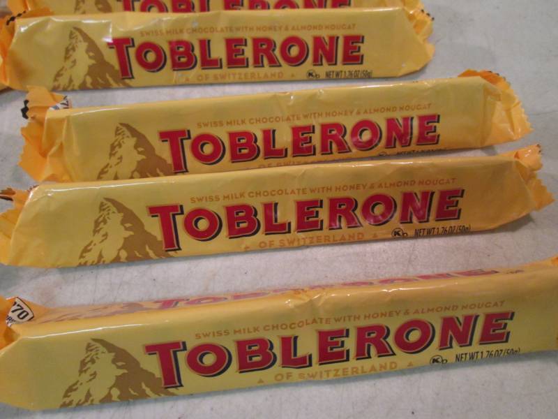 lot 106 image: 12 Toblerone Candy Bars Best by Aug...
