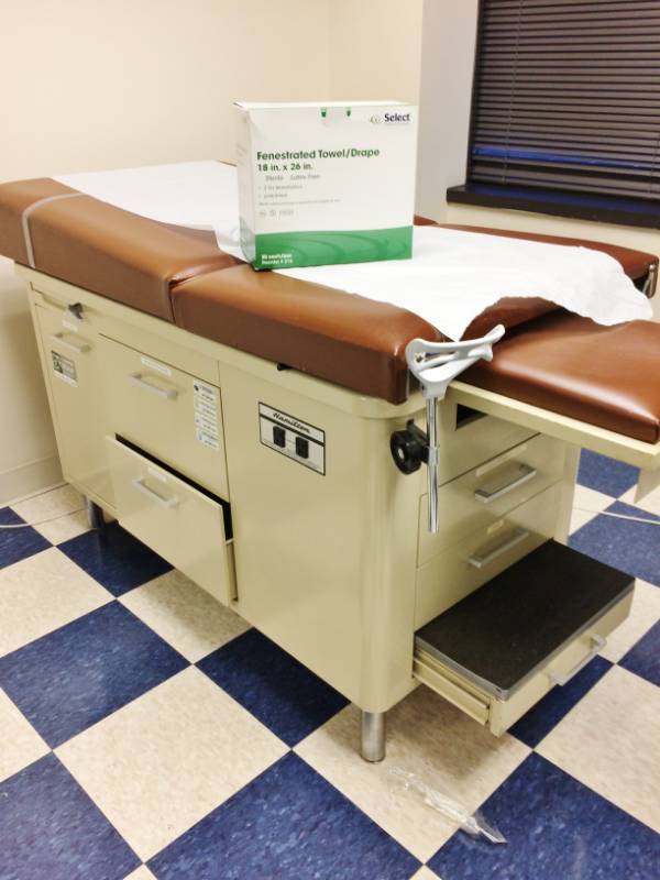 lot 5 image: MSRP $1200 Super Nice FAMILY PRACTICE OBGYN MEDICAL VETERINARIAN TREATMENT EXAMINATION TABLE WITH STEP UP STOOLS, TUCKAWAY STIRRUPS, STORAGE DRAWERS & 1 DOOR CABINET ALSO INCLUDES EXTRA PAPER ROLLS & FENESTRATED TOWELDRAPES
