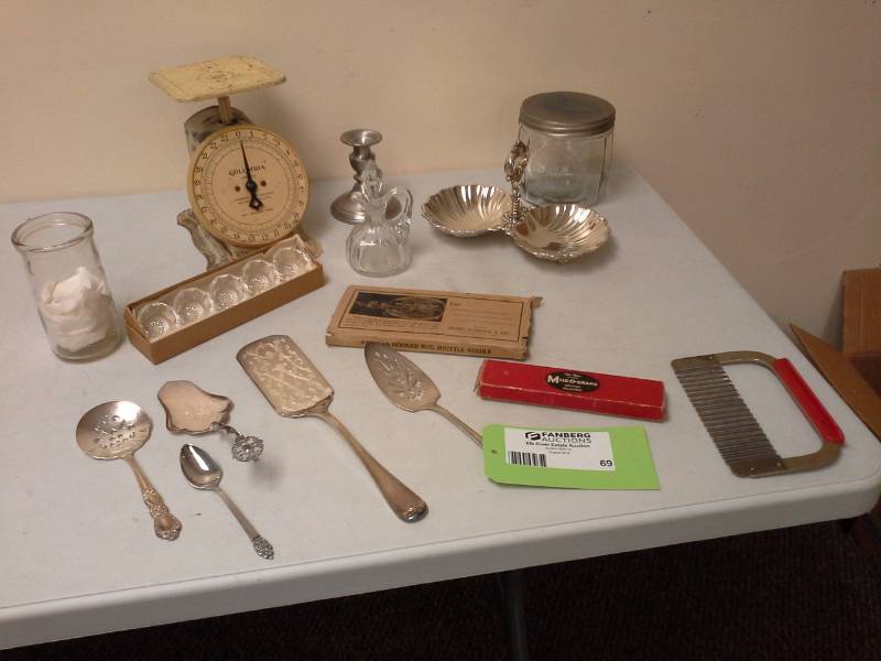 lot 69 image: Silver Serving Utensils, Analog Food Scale, Cheese Slicer, Metal Serving Trays, Glass Jars, Sears Rug Needle, Precision Mile-o-graph Mileage Measurer
