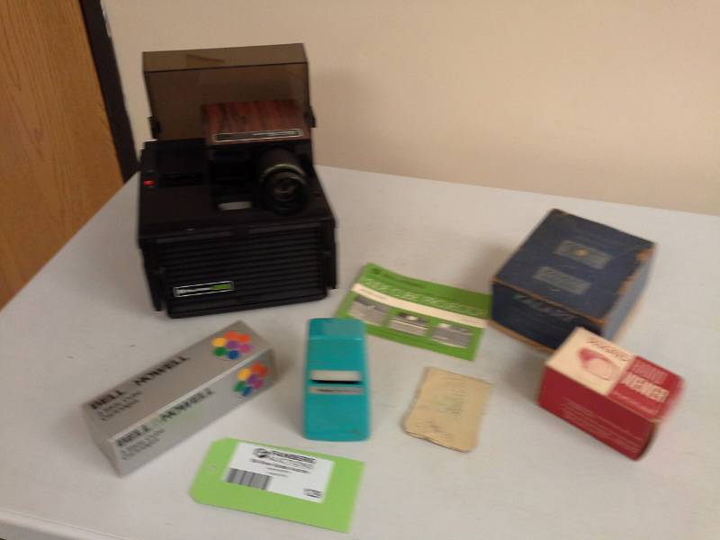 lot 129 image: Bell & Howell System II Slide Cube Projector RC50 with Instructions, Slide Cartridges, Montgomery Ward Hand ViewerKalart Speed FlashRange Finder