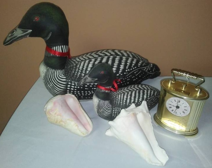 lot 138 image: Bulova alarm clock, loons and shells.