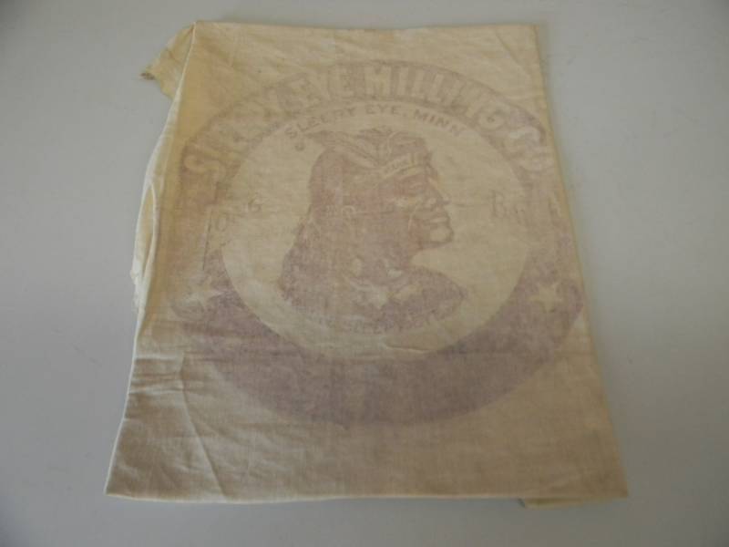 lot 33 image: VINTAGE ORIGINAL SLEEPY EYE MILLING CO. - INDIAN CHIEF OLD SLEEPY EYE ADVERTISING SIGN ON MATERIAL - VERY COOL - APPROX 12 BY 15 - SEE PICTURES