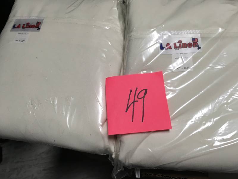 lot 49 image: 90 in. x 132 in. Ivory Polyester Poplin Rectangular Tablecloth by LA Linen not used
