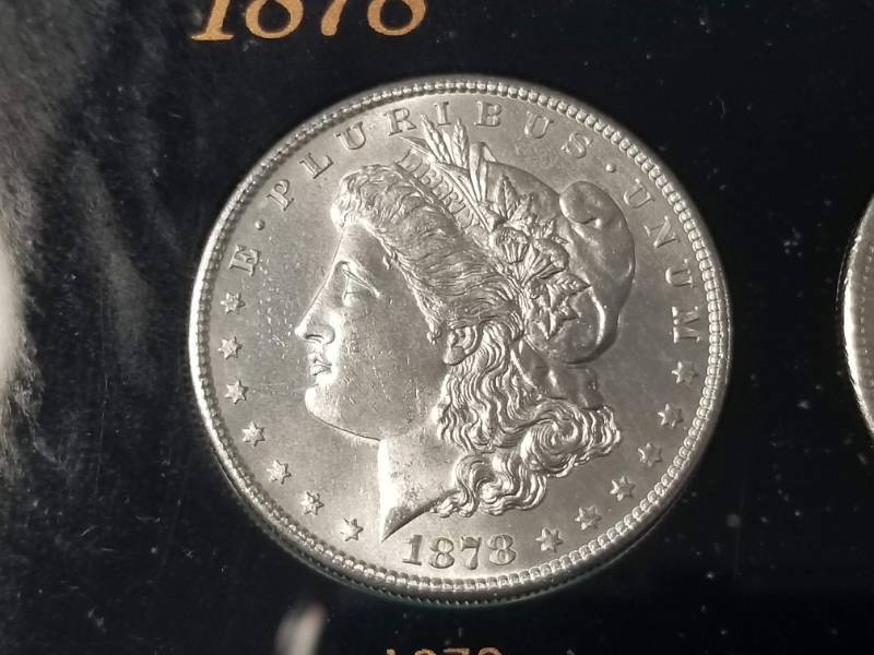 lot 02-A image: DATE SET OF 27 AU-BU MORGAN SILVER DOLLARS IN CAPITAL HOLDER