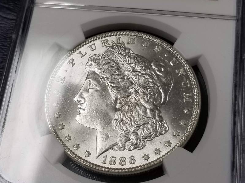 lot 23 image: 1886 MORGAN SILVER DOLLAR MS64 NGC (plus designation)