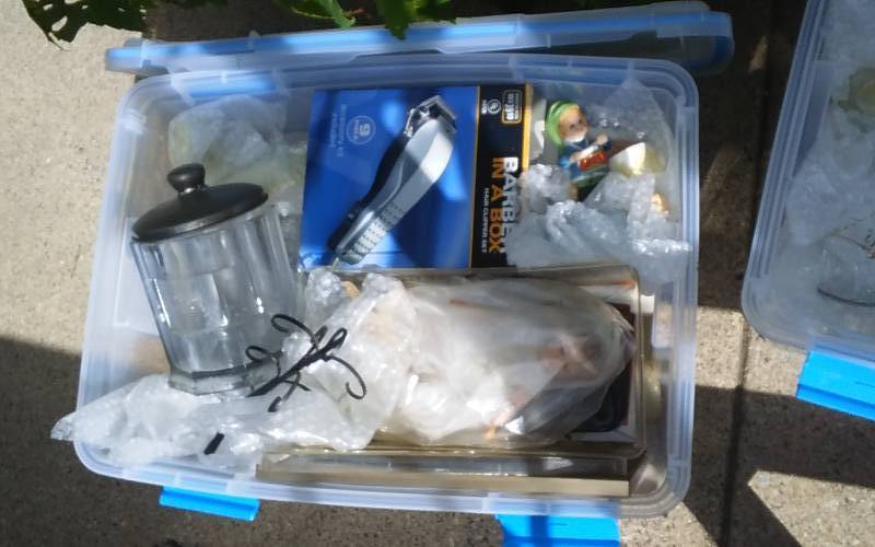 lot 61 image: Sterilite 54-Qt Gasket Bin With Lid & Unknown Wrapped Contents
