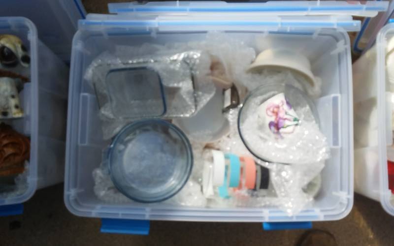lot 71 image: Sterilite 54-Qt Gasket Bin With Lid & Unknown Wrapped Contents