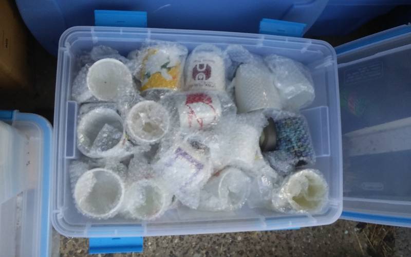 lot 74 image: Sterilite 54-Qt Gasket Bin With Lid & Unknown Wrapped Contents