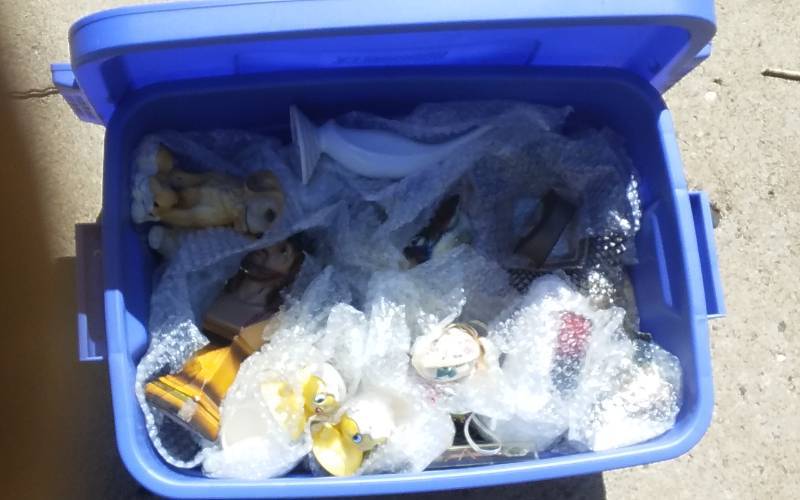 lot 77 image: 10-Gallon Rubbermaid Bin With Lid & Unknown Wrapped Contents
