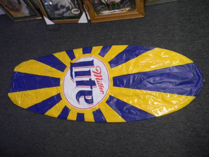 lot 47 image: MILLER LITE MILLER GENUINE DRAFT INFLATABLE SURFBOARD WITH LOOPS TO HANG - NOS - VERY COOL DISPLAY - APPROX 60 BY 30 - SEE PICTURES