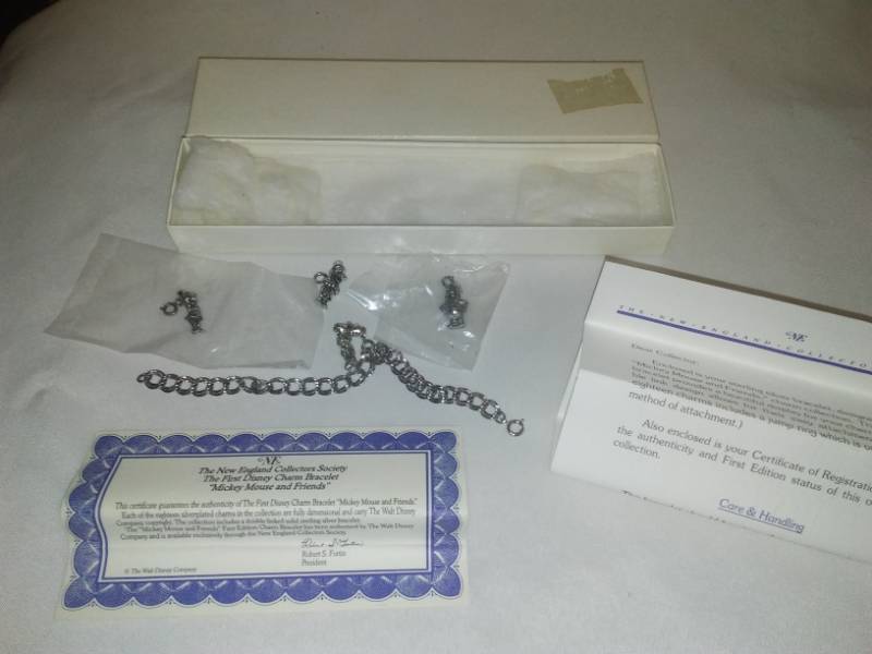 lot 60 image: The first Disney charm bracelet and four charms.