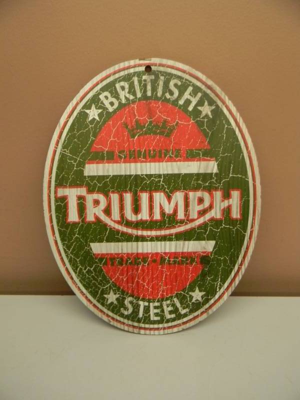 lot 25 image: TRIUMPH MOTORCYCLE OVAL WOOD - APPROX 15 BY 12 - SEE PICTURES