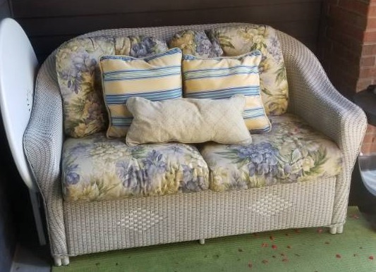 lot 32 image: White Wicker Loveseat and Ottoman by Lloyd Flanders