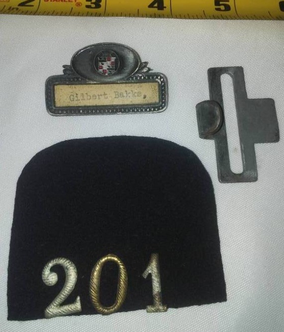 lot 240 image: WWI Gilbert Bakke nameplate buckle and metal numbers.