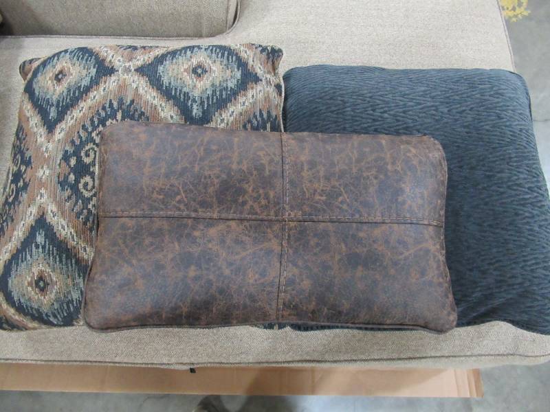lot 180 image: NEW ASHLEY 3 Beautiful Accent Pillows in Hues of Browns and Blues.