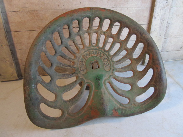 lot 34 image: Antique CHAMPION Embossed Iron Tractor Seat