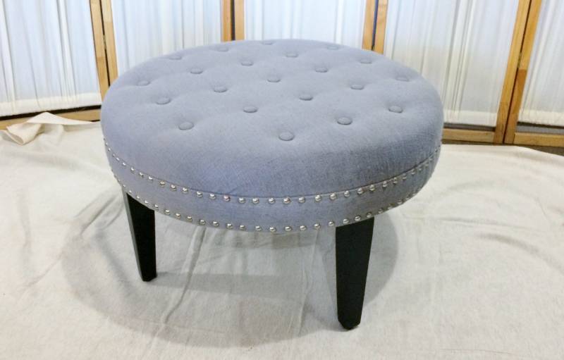 Stylish Large Round Grey Upholstered Button Tufted Cushioned Ottoman With Silver Nailhead Trim &amp Black Wood Legs - Great Condition - No Stains Or Tears