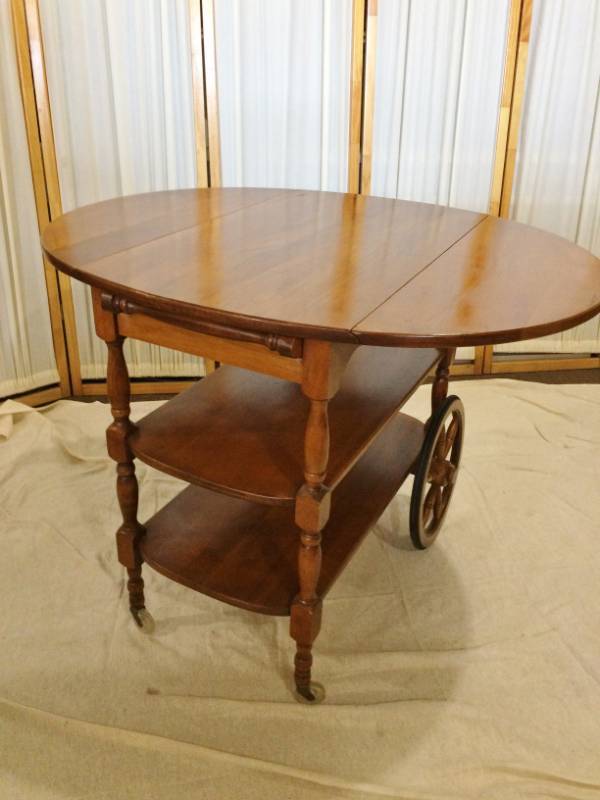 Circa 1950s&nbspHard Rock Maple Drop Leaf Tea Serving Table Cart Trolley wDrawer &amp Two Shelves - Handle Tucks Away &amp Leaves Lock Into Place To Create A 4 Guest Round Dinner Table - Excellent Condition