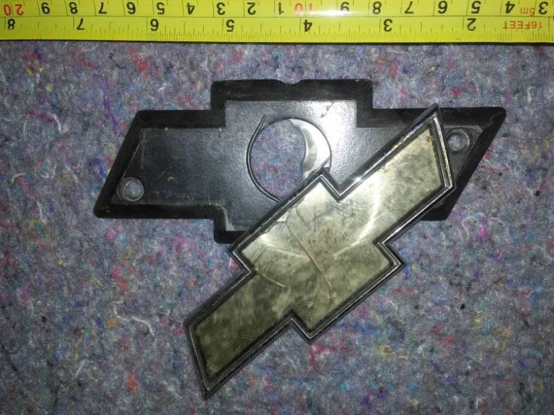 lot 27 image: Chevy Truck 8 350 Front Fender Badging and bow tie trunk key guard gold