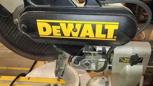 lot 152 image: DeWalt model DW708 - 12  Sliding Compound Miter Saw on Rolling metal Rack NEXT TO NEW