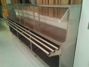 lot 312 image: Stainless Steel Serving Bar with sneeze guard. 10 ft. L pull up tray counters, under storage, 55in H x 20in. Depth.