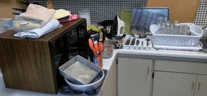 lot 447 image: Kitchen Misc. from one cooking pod in Home Ec. Nice condition. Iron, Microwave and cookware