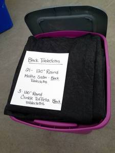 lot 331 image: Lot of (24) Black Matte Satin Tablecloths 120in. Round, Black Crinkle Taffeta Tablecloths 120in. Round
