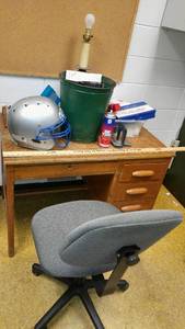 lot 1414 image: Desk with contents 42 x 26 x 30 (chair, Football helmet, First aid supplies and more.